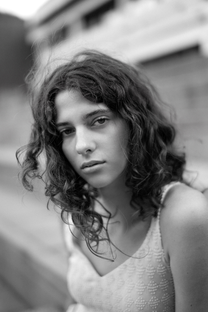 A girl in a dress sitting on the steps