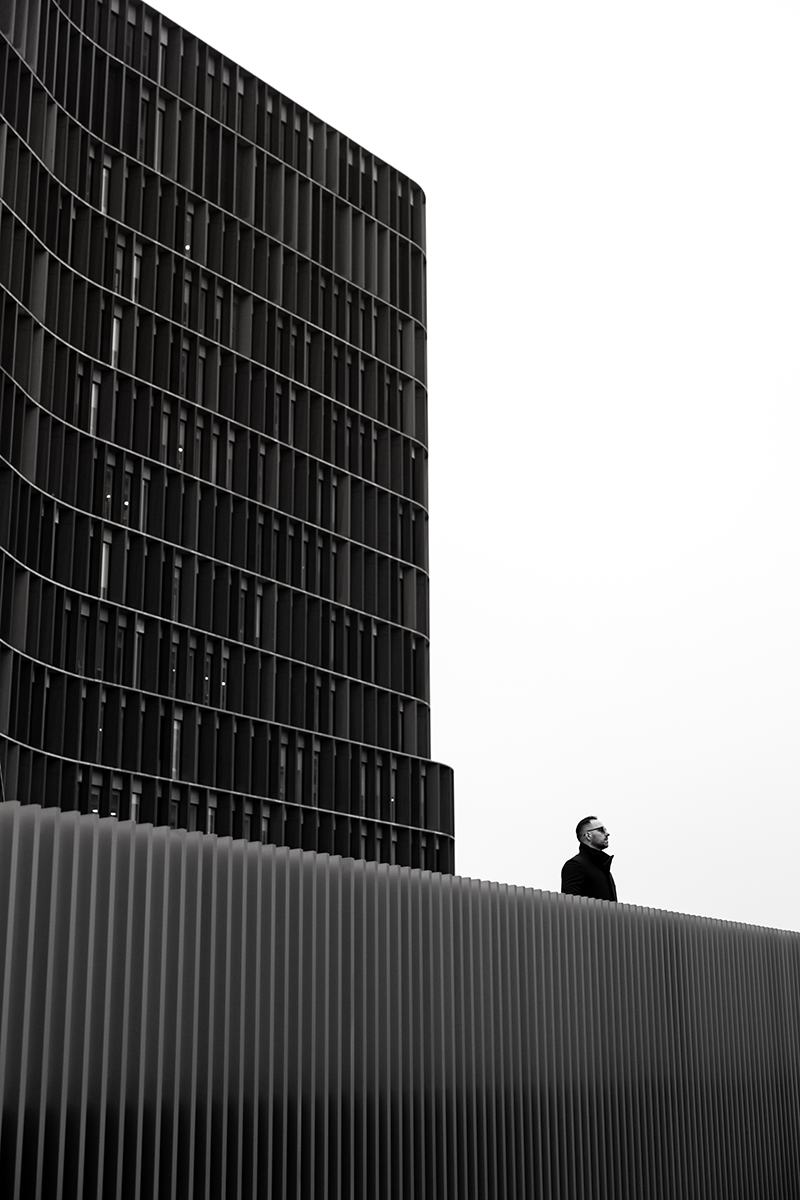 A man ooking straight ahead against the backdrop of the Panum office building in Copenhagen