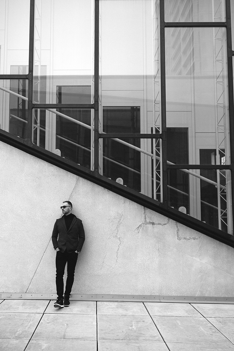 A man in a blazer leaning against the wall of the Herlev Hospital auditorium in Copenhagen