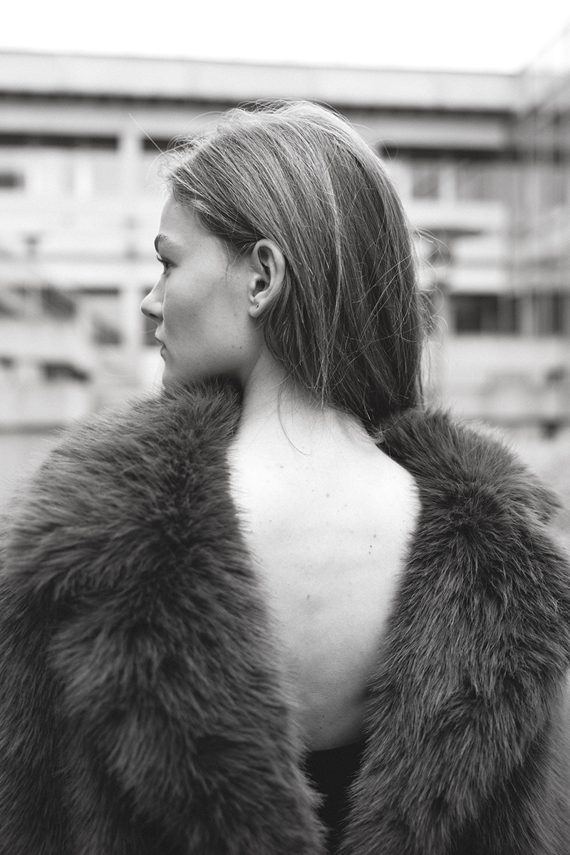 A woman in a faux fur coat with an open back