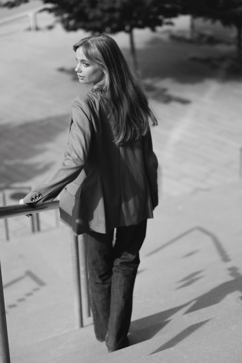 A woman seen from behind, walking down the stairs and looking back