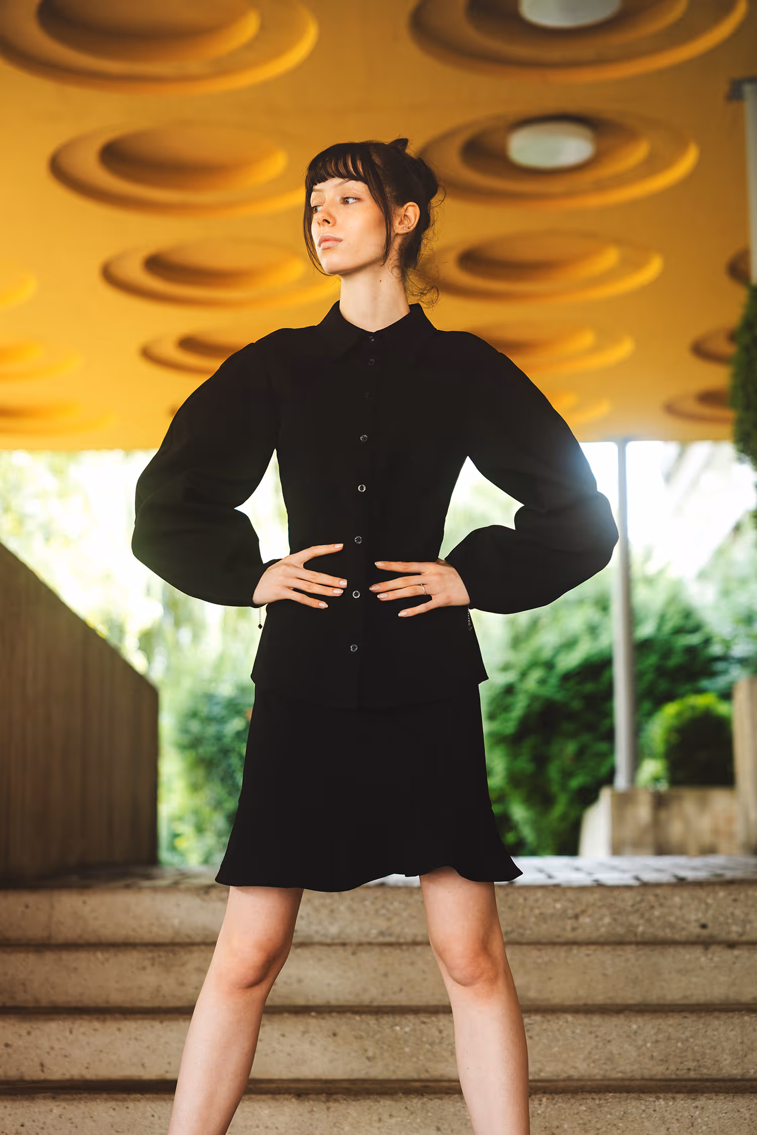 Standing woman in black outfit holding her hips