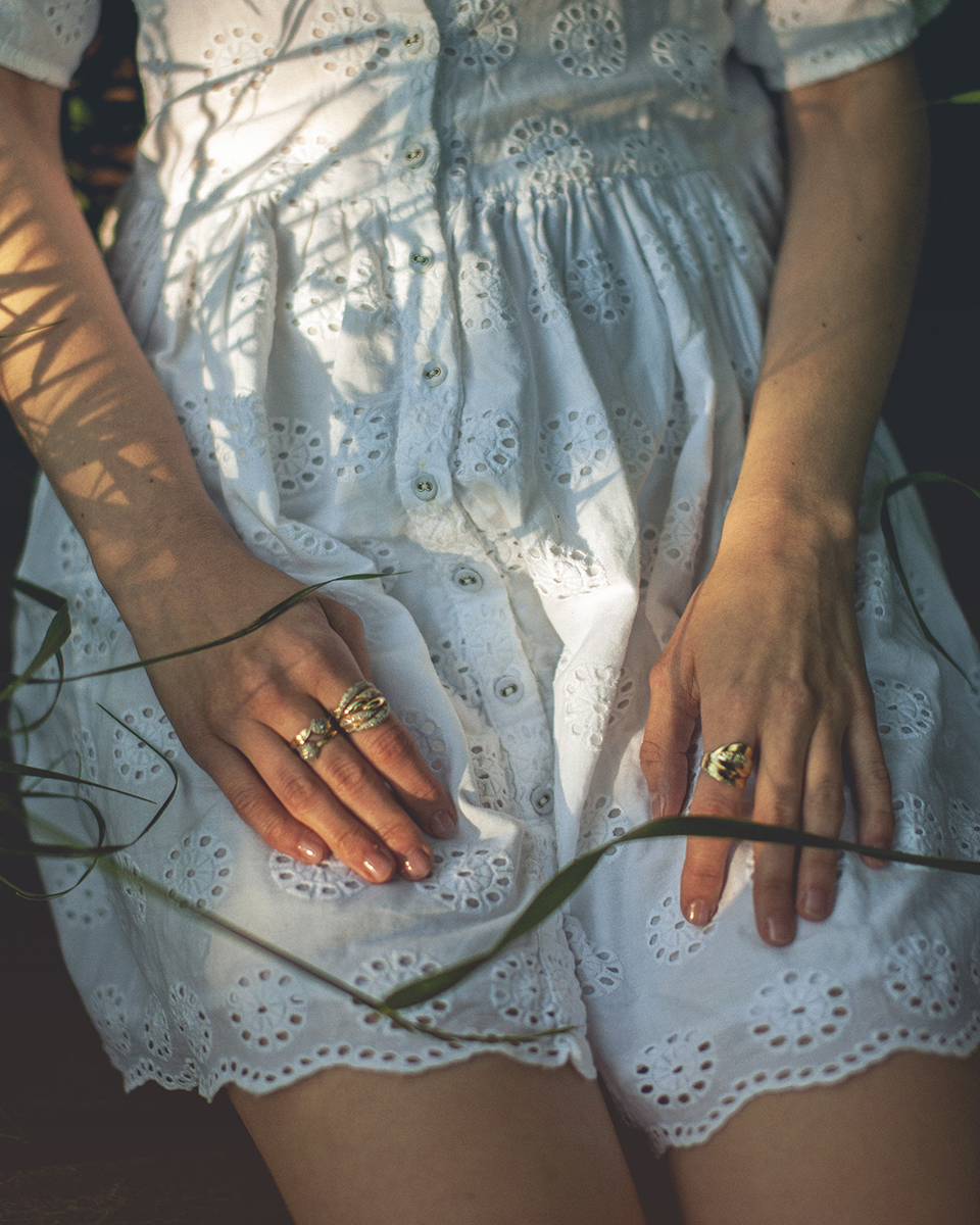 The torso of a woman lying in a meadow with her hands on her thighs