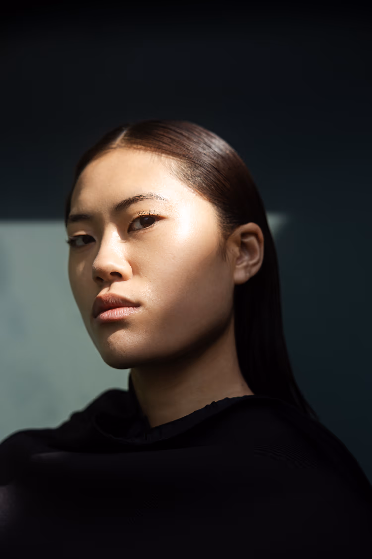 High-contrast futuristic fashion portrait from the Monolith Brut session, featuring a model with sharp shadow play outside the DR building in Aarhus.